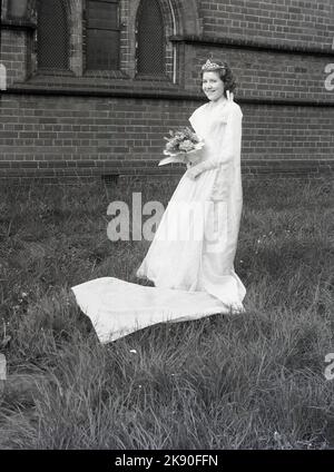 1961, historisch, May Queen, ein Teenager-Mädchen in ihrem Kleid und mit einer Krone, die draußen auf dem Gelände einer Kirche steht, Leeds, England, Großbritannien. Der 1. Mai ist ein traditionelles Fest zu Beginn des Sommers und geht auf eine alte Zeit zurück. Stockfoto