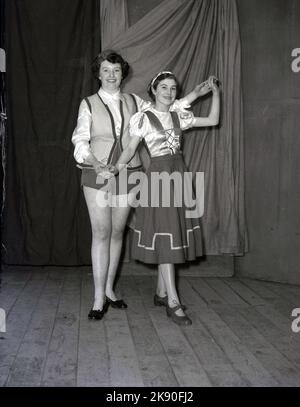 1955, historisch, Februar, zwei junge Frauen, Amateurdarstellerinnen, Gemeinsam posieren sie auf der Bühne für ihr Foto, in den Kostümen, die sie in der Winterpantomine tragen, Robin Hood, Leeds, England, Großbritannien. Stockfoto