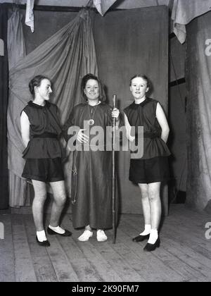 1955, historisch, Februar, drei Teenager in Kostümen posieren auf der Bühne für ihr Foto, sie sind in der Pantomine, Robin Hood, Leeds, England, Großbritannien. Der Mönch Bruder Tuck mit seinen zwei fröhlichen (wo) Männern. Stockfoto