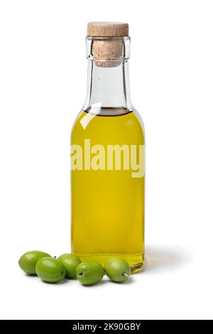 Flasche Olivenöl mit einem Haufen von frischen rohen grünen Oliven vor isoliert auf weißem Hintergrund Stockfoto