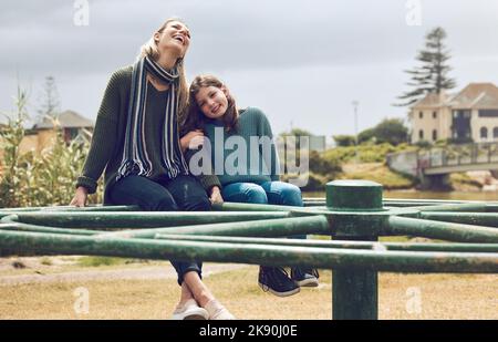 Mutter, Kind und Umarmung, Spielplatz und im Park Spaß beim fröhlichen Spielen machen Runde und verbinden sich gemeinsam im Freien in der Natur. Frau, Mädchen und Lachen, Kindheit Stockfoto