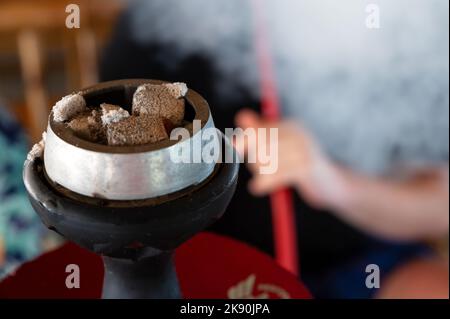 Blick auf brennende Shisha-Kohlen in Shisha-Schale aus nächster Nähe. Stockfoto