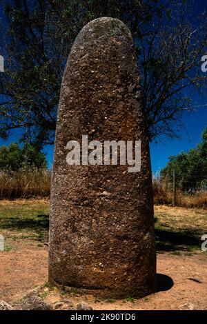 Der Almendres Menhir unterscheidet sich von den Megalith-Ringen des Almendres Cromlech bei Évora, Alentejo Central, Portugal. Allerdings scheint der Granit stehende Stein Teil des gleichen prähistorischen Entwurfs gewesen zu sein, denn von den Steinkreisen des Hauptmonuments aus gesehen, zeigte er auf den Sonnenaufgang der Sommersonnenwende. Stockfoto