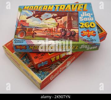 Vintage-Puzzle-Boxen aus den 60er Jahren, hell bemalte Illustrationen einer Skiffle-Gruppe auf der Bühne und einem Düsenflugzeug. Sehr populistisches Design und Schriften, die der Ära erhaben sind. Flach und als Pack Shots gestapelt. Stockfoto