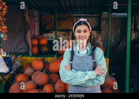 Die Bäuerin verkauft auf dem Markt die Herbsternte der Kürbis Stockfoto