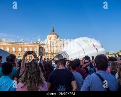 Das Publikum konzentriert sich beim Aranjuez Hot Air Balloon Festival um die Ballons, während sie aufgeblasen werden. Stockfoto