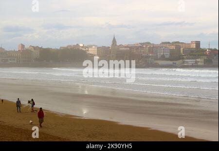 Hundespaziergänger am Strand an einem windigen Oktobernachmittag Playa de San Lorenzo Gijon Asturias Spanien Stockfoto