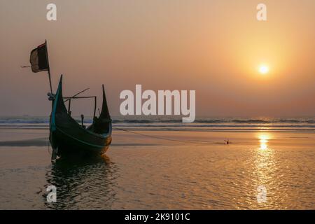 Blick auf den Sonnenuntergang auf das wunderschöne traditionelle hölzerne Fischerboot, das als Mondboot bekannt ist, am Strand in der Nähe von Cox's Bazar im Süden von Bangladesch Stockfoto