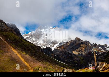 Die wunderschönen schneebedeckten Berge im Yumesamdong Tal mit flauschigen Wolken überzogen Stockfoto
