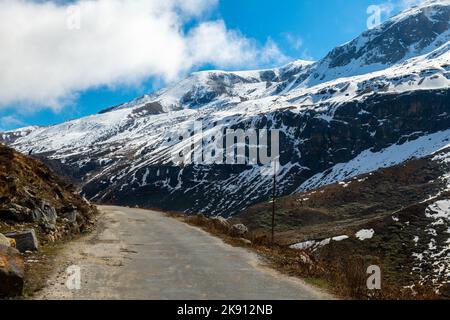 Die wunderschönen schneebedeckten Berge im Yumesamdong Tal mit flauschigen Wolken überzogen Stockfoto
