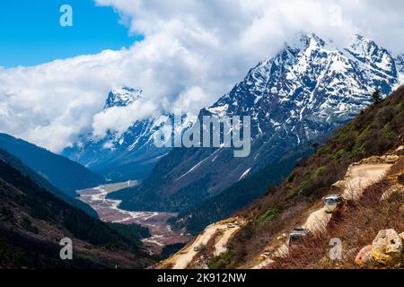 Die wunderschönen schneebedeckten Berge im Yumesamdong Tal mit flauschigen Wolken überzogen Stockfoto