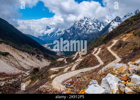 Die wunderschönen schneebedeckten Berge im Yumesamdong Tal mit flauschigen Wolken überzogen Stockfoto