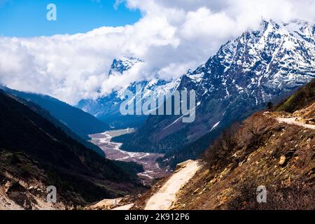 Die wunderschönen schneebedeckten Berge im Yumesamdong Tal mit flauschigen Wolken überzogen Stockfoto