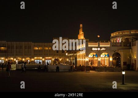 Fanar - Qatar Islamic Cultural Center, Doha, Katar bei Nacht, mit Souq Waqif im Vordergrund und dem Mond nim Hintergrund Stockfoto