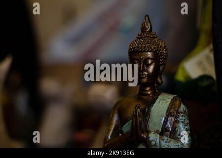 Nahaufnahme einer gebeteten Buddha-Statue aus Bronze mit geschlossenen Augen Stockfoto