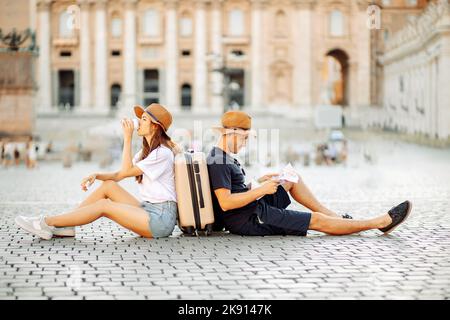 Müde Touristen auf einer Karte und trinken Kaffee zum Mitnehmen. Urlaub in Italien. Umzug Stockfoto