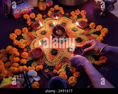 Kathmandu, Bagmati, Nepal. 25. Oktober 2022. Eine Frau betet an die Göttin Laxmi, die Hindu-Göttin des Reichtums, nachdem sie am 25. Oktober 2022 in Kathmandu, Nepal, das farbenfrohe Rangoli zur Feier von Tihar oder Diwali vorbereitet hat. Tihar, das hinduistische Fest der Blumen und Lichter, wird fünf Tage lang gefeiert. (Bild: © Sunil Sharma/ZUMA Press Wire) Stockfoto