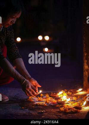 Kathmandu, Bagmati, Nepal. 25. Oktober 2022. Eine Frau betet mit zünden Butterlampen zur Feier von Tihar oder Diwali, dem Lichterfest in Kathmandu, Nepal, am 25. Oktober 2022. Tihar, das hinduistische Fest der Blumen und Lichter, wird fünf Tage lang gefeiert. (Bild: © Sunil Sharma/ZUMA Press Wire) Stockfoto