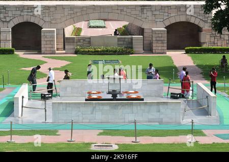 Menschen, die neben dem Mahatma Gandhi gewidmeten Denkmal in Raj Ghat, Neu-Delhi, Indien, stehen Stockfoto