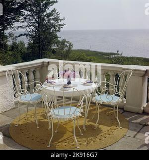 Gartenmöbel der 1950s. Ein Set passender Gartenmöbel aus Gusseisen mit blauen Kissen auf einer Terrasse. Schweden 1958 Ref. CV83 Stockfoto