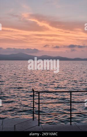 Die Sonne untergeht über der Adria, von der Küste von Zadar in Kroatien gesehen, beschrieben von Alfred Hitchcock Stockfoto