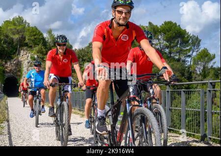 Eine Gruppe norwegischer Radfahrer mittleren Alters überquert eine Brücke auf der stillgegangenem Spoleto zur Norcia-Bahn mit gemieteten Fahrrädern. Umbrien, Italien. Stockfoto