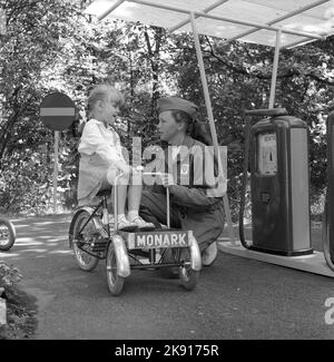 In der 1950s. Ein Mädchen auf einem Dreirad nimmt an einer Kinderverkehrsschule Teil, wo die Kinder lernen, sich im Verkehr zu verhalten. Straßen und Häuser sind kleiner als üblich und sogar die Tankstelle ist da, wo ein Service-Mitarbeiter die Kinder betreut und bei der Make-believe-true-Übung mitspielt. Das Jahr ist 1958. Schweden Ref. CV79 Stockfoto