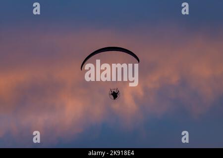 Ein motorbetriebener Gleitschirm, der bei Sonnenuntergang in der Nähe von Hanksville, Utah, fliegt. Stockfoto