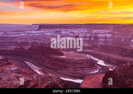 Ein farbenfroher Sonnenuntergang im Winter über dem Goose Neck des Colorado River vom Dead Horse Point State Park, Moab, Utah. Stockfoto