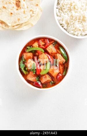 Thailändisches rotes Hühnerfleisch mit Gemüse in Schüssel auf weißem Hintergrund mit freiem Textraum. Draufsicht, flach liegend Stockfoto