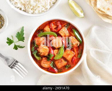 Thailändisches rotes Chicken-Chicken-Pusterklauch mit Gemüse in einer Schüssel auf weißem Hintergrund. Draufsicht, flach liegend Stockfoto