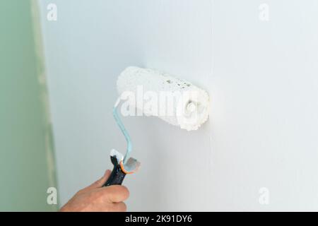 Nahaufnahme der Handbemalung der Wand mit einer Walze. Speicherplatz kopieren. Stockfoto