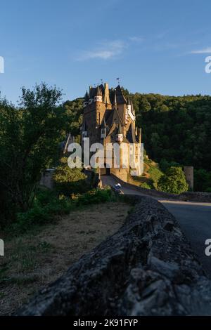 Eine vertikale Aufnahme des Schlosses Eltz, das an einem sonnigen Tag von Bäumen umgeben ist Stockfoto