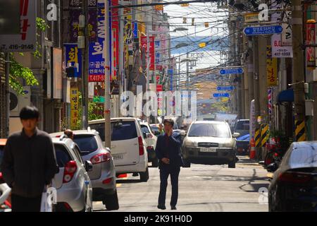 Eine schöne Aufnahme von Menschen, die auf der Straße in der Innenstadt von Busan, Südkorea, spazieren gehen Stockfoto