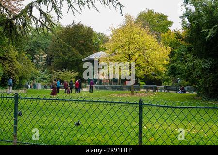 Menschen genießen einen schönen Herbsttag auf dem Square du Temple - Elie Wiesel, wo einst das Schloss der Tempelritter stand, Paris, Frankreich. Stockfoto