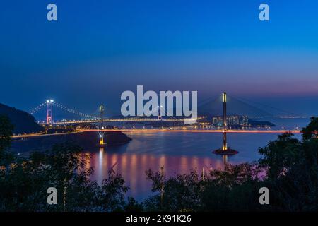 Eine bezaubernde Sonnenuntergangsansicht der Tsing Ma Bridge in Hongkong mit abendlicher Beleuchtung, China Stockfoto