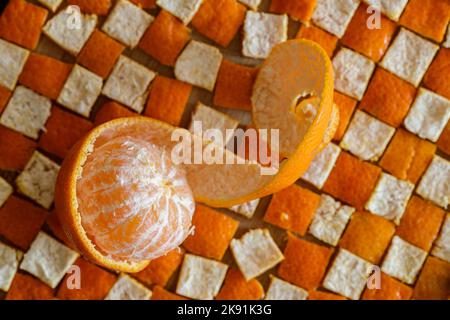 die mandarinorange schälte sich auf der Schale in Quadraten Stockfoto