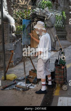 Eine vertikale Aufnahme eines älteren asiatischen Gentleman, der ein Bild auf der Straße malte Stockfoto