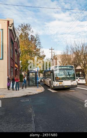 Vier Frauen stehen an der Ecke vor dem Wartebereich des Busses vor Urban Outfitters im Packard Building an der NW 23. Avenue in Portland, Oregon. Stockfoto