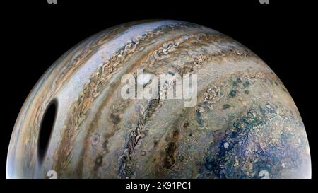 Platz. 24. Oktober 2022. Jupiter im Schatten von Ganymede während des 40.-Grad-Passes durch Jupiter sah unsere Juno-Sonde Ganymede am 25. Februar 2022 einen großen, dunklen Fleck auf den Planeten werfen. JunoCam hat dieses Bild ganz nah an Jupiter aufgenommen, wodurch Ganymedes Schatten besonders groß erscheint. Zu der Zeit, als das Rohbild aufgenommen wurde, befand sich die Juno-Sonde etwa 44.000 Meilen (71.000 Kilometer) über Jupiters Wolkenspitzen und 15-mal näher am Planeten als Ganymede. Ein Beobachter an den Spitzen der Jupiterwolke innerhalb des ovalen Schattens würde eine totale Sonnenfinsternis erleben. Totale Sonnenfinsternisse sind häufiger o Stockfoto