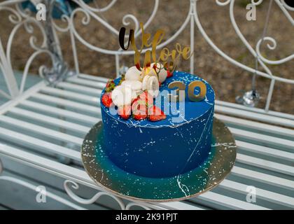 30 Jahre Jubiläum blauer Kuchen mit Erdbeeren auf goldenem Teller Stockfoto