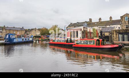 Farbenfrohe, schmale Boote im Skipton-Kanalbecken in Yorkshire, aufgenommen im Oktober 2022. Stockfoto