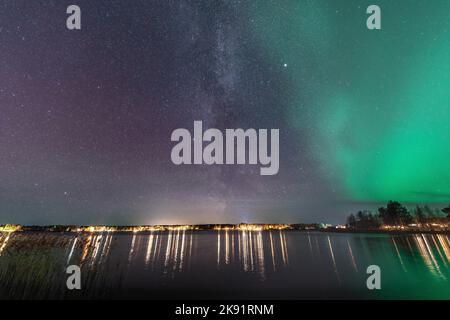 Wunderschöne Milchstraßengalaxie in der Nähe von Aurora, malerisches Panorama von Nordlichtern über den ruhigen Stocksjo See in Nordschweden, Umea Stadt. Nachtschicht Stockfoto