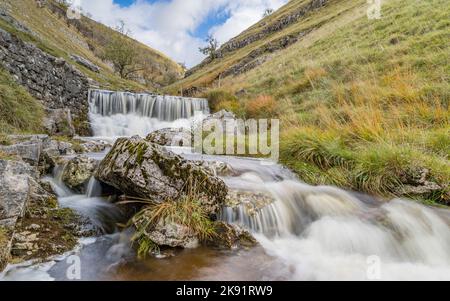 Wasser fließt über eine Reihe kleiner Wasserfälle hinunter nach Bucken Beck in den Yorkshire Dales, die als lange Exposition festgehalten wurden, um die Bewegung des Wassers zu verwischen. Stockfoto