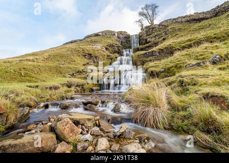 Eine lange Belichtung verwischt die Bewegung des Wassers, das einen wunderschönen Wasserfall bei Cray in den Yorkshire Dales hinunterfließt. Stockfoto