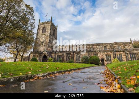 Blätter säumen einen Pfad zur Holy Trinity Church in Skipton, Yorkshire, die im Oktober 2022 gesehen wurde. Stockfoto