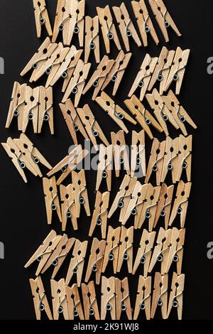 Reihe Holz Wäscheklammern auf schwarzem Hintergrund Stockfoto
