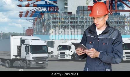 Port Manager mit einem digitalen Tablet vor dem Hintergrund eines mit Containern beladenen LKW und Schiffes im Seehafen Stockfoto