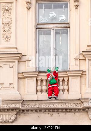 Wien, Österreich - 27. November 2010: Der weihnachtsmann klettert eine historische Fassade hinauf Stockfoto