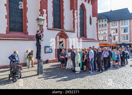 FRANKFURT, DEUTSCHLAND - 9. AUG 2014: Ehepaar mit Familie posiert für ein Hochzeitsfoto vor der Frankfurter Nicolai-Kirche. Stockfoto